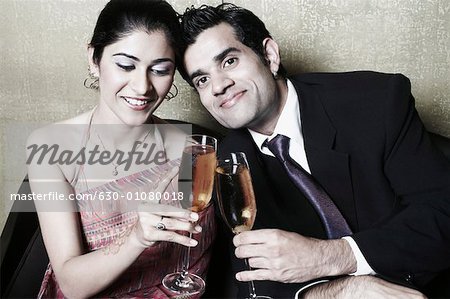 Close-up of a businessman and a businesswoman holding champagne flutes