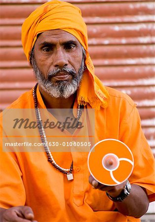 Close-up of a mature man holding a cd, Pushkar, Rajasthan, India