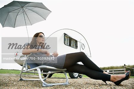 Woman Sitting on Lawn Chair by Trailer