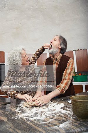 Woman Feeding Man while Making Pastry