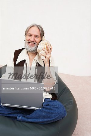 Homme avec ordinateur portable à l'écoute de Seashell