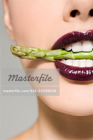 Woman with asparagus in her mouth