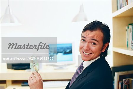 Portrait of a businessman holding a CD