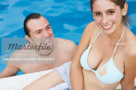 Mid adult man and a young woman smiling in a swimming pool