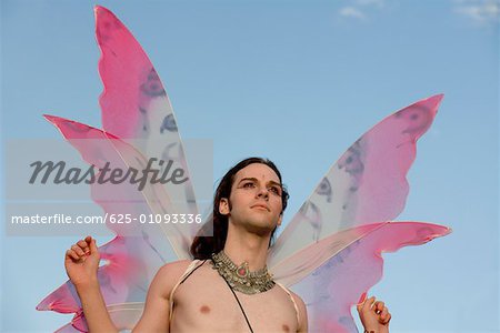 Faible angle vue d'un homme gay torse nu dans un costume de fée