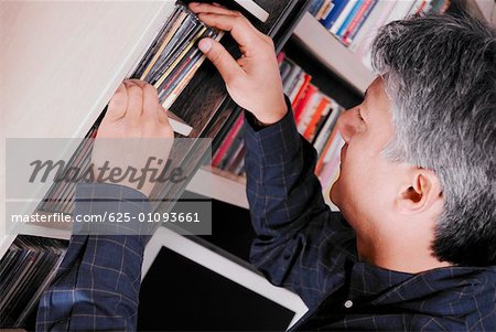 Side profile of a senior man looking for a CD