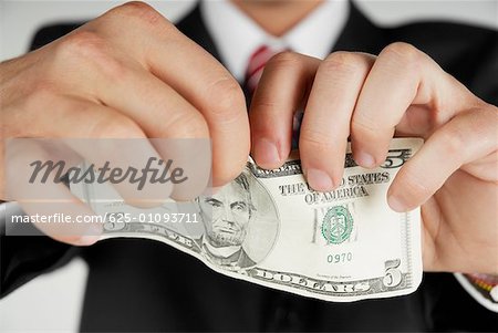 Gros plan des mains d'un homme tenant un billet d'un dollar américain