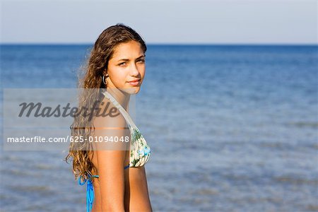 Seitenprofil ein Teenager-Mädchen am Strand stehend