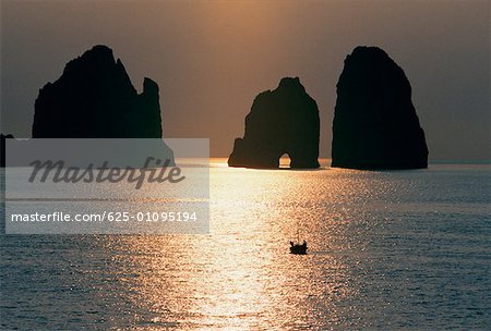 Silhouette der Felsen im Meer bei Sonnenaufgang, Capri, Italien