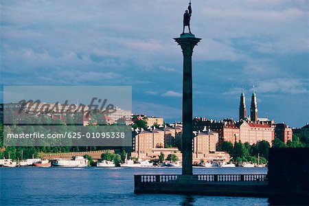 Flachwinkelansicht einer Statue auf einer Säule in einem Hafen, Stockholm, Schweden