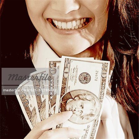 Close-up of a businesswoman holding dollar bills and smiling