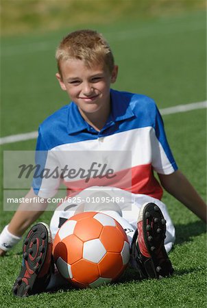 Portrait of a soccer player sitting with a soccer ball