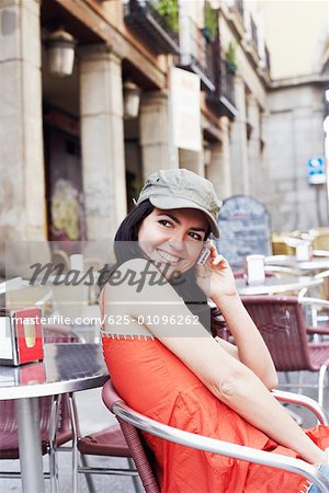 Side profile of a mid adult woman sitting at a sidewalk cafe
