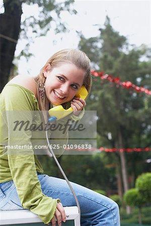 Side profile of a young woman talking on the telephone