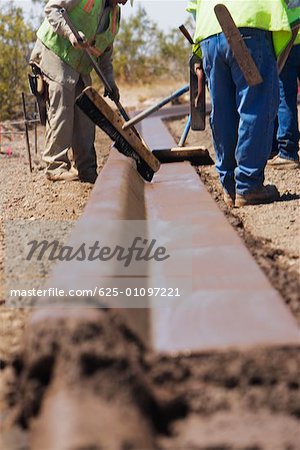 Drei Bauarbeiter auf einer Baustelle arbeiten