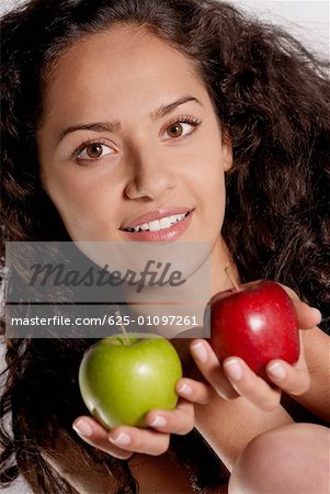 Porträt einer jungen Frau hält zwei Äpfel