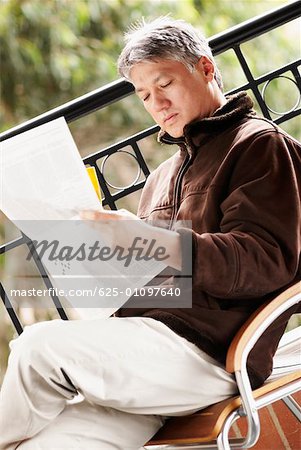 Side profile of a senior man reading a newspaper