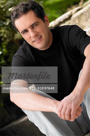Porträt eines jungen Mannes sitzend mit seiner Hände