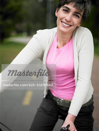 Portrait of a mature woman sitting on a bicycle and smiling