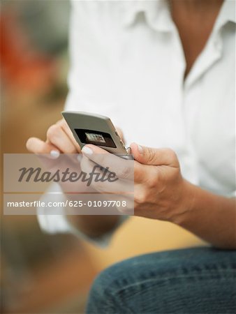 Mid section view of a woman operating a mobile phone