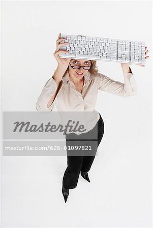 High angle view of a businesswoman holding a computer keyboard over her head