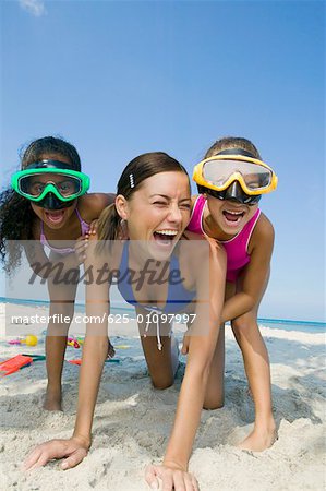 Close-up of a young woman playing with two girls on the beach