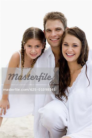 Portrait of a young couple and their daughter smiling