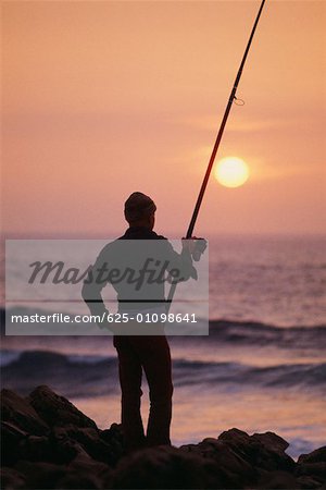 Silhouette von einem Fischer hält eine Angelrute, Portugal