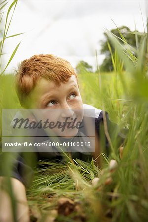Portrait of Boy Peeking through Long Grass