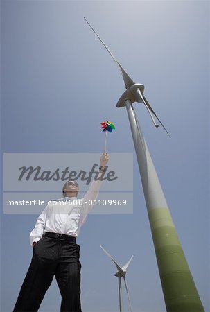 Businessman with Pinwheel by Wind Turbine