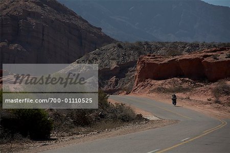 Man Biking Through Canyons, Quebrada de las Conchas, Salta Province, Argentina