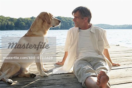 Homme à l'extérieur avec le chien, trois Mile Lake, Muskoka, Ontario, Canada