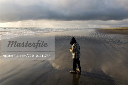 Garçon debout sur la plage, parc d'état de Fort Stevens, Oregon, Etats-Unis