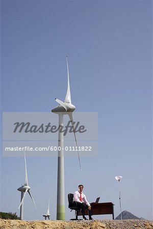 Mann sitzt am Schreibtisch von Windparks