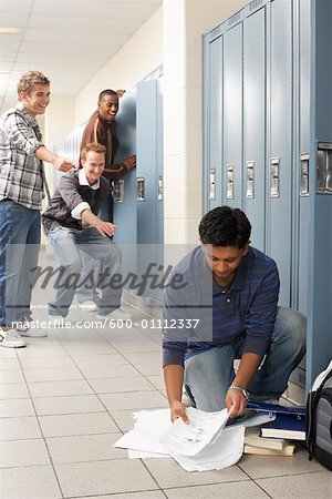 Friends Laughing at Boy Dropping Notes by Locker