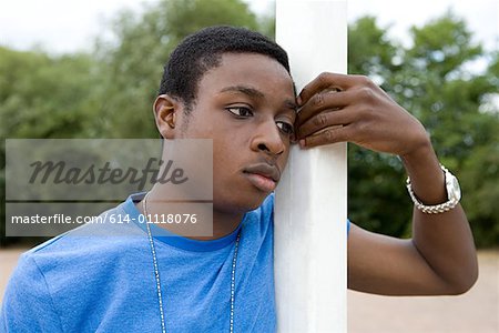 Boy leaning on goalpost