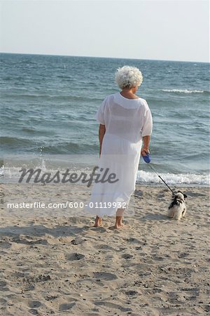 Frau Wandern Hund am Strand