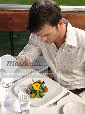 Homme mange seul à l'extérieur
