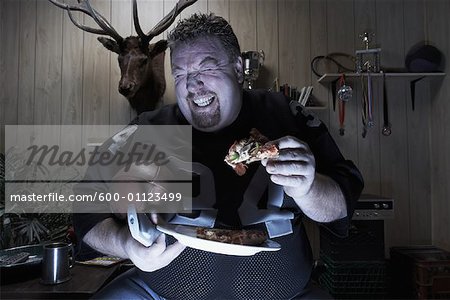 Man Watching TV and Eating Pizza
