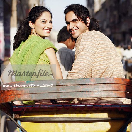 Rear view of a young couple sitting in a rickshaw