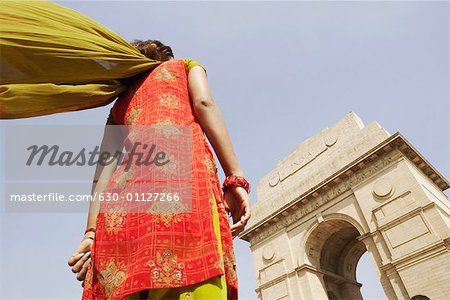 Low angle view of a woman standing in front of a monument, India Gate, New Delhi, India
