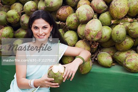 Portrait d'une jeune femme tenant une noix de coco