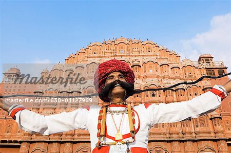 Faible angle vue d'un homme d'âge mûr tenant sa moustache devant un palace, Hawa Mahal, Jaipur, Rajasthan, Inde