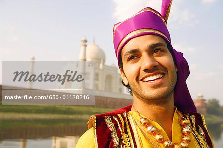 Nahaufnahme eines jungen Mannes lächelnd vor einem Mausoleum, Taj Mahal, Agra, Uttar Pradesh, Indien