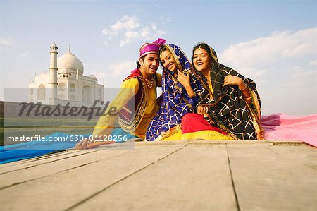 Porträt eines jungen Mannes und zwei junge Frauen sitzen in einem Boot, Taj Mahal, Agra, Uttar Pradesh, Indien