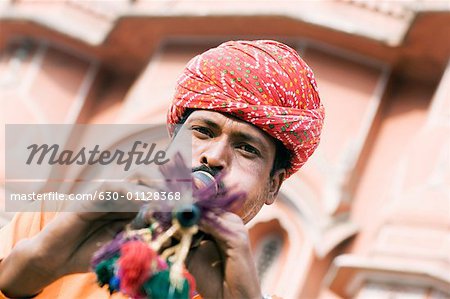 Portrait d'un charmeur de serpent jouant d'une flûte devant un palace, Hawa Mahal, Jaipur, Rajasthan, Inde
