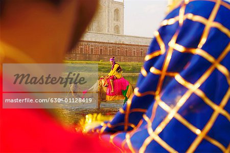 Rückansicht von zwei Menschen, ein Mann Reiten ein Kamel, Taj Mahal, Agra, Uttar Pradesh, Indien