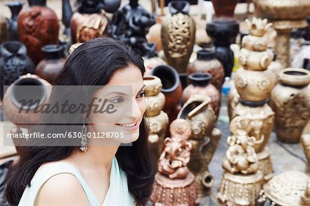 Side profile of a young woman smiling in a pottery store