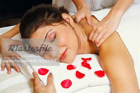 Close-up of a young woman getting a shoulder massage from a massage therapist