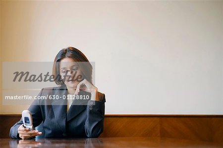 Close-up of a businesswoman using a mobile phone in a conference room